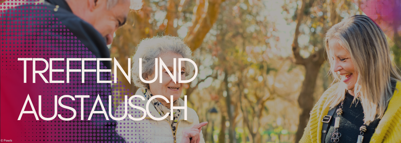 An einem Tisch sitzen ein älterer Mann und zwei Frauen. Sie lachen miteinander.