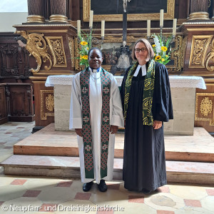 Pfarrerin Marjaana Marttunen und Pastor John Mwasakiliali vor dem Alter der Dreieinigkeitskirche